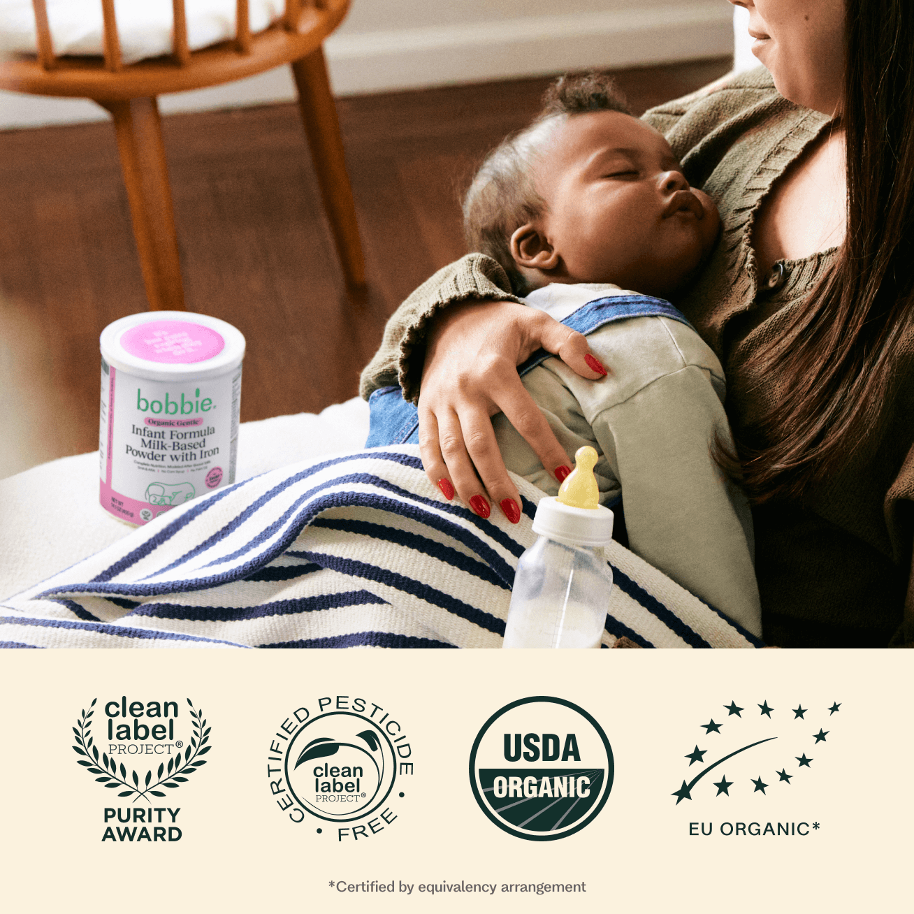 Woman holding a baby with a bobble infant formula container and a bottle on a blanket, with certification logos at the bottom.