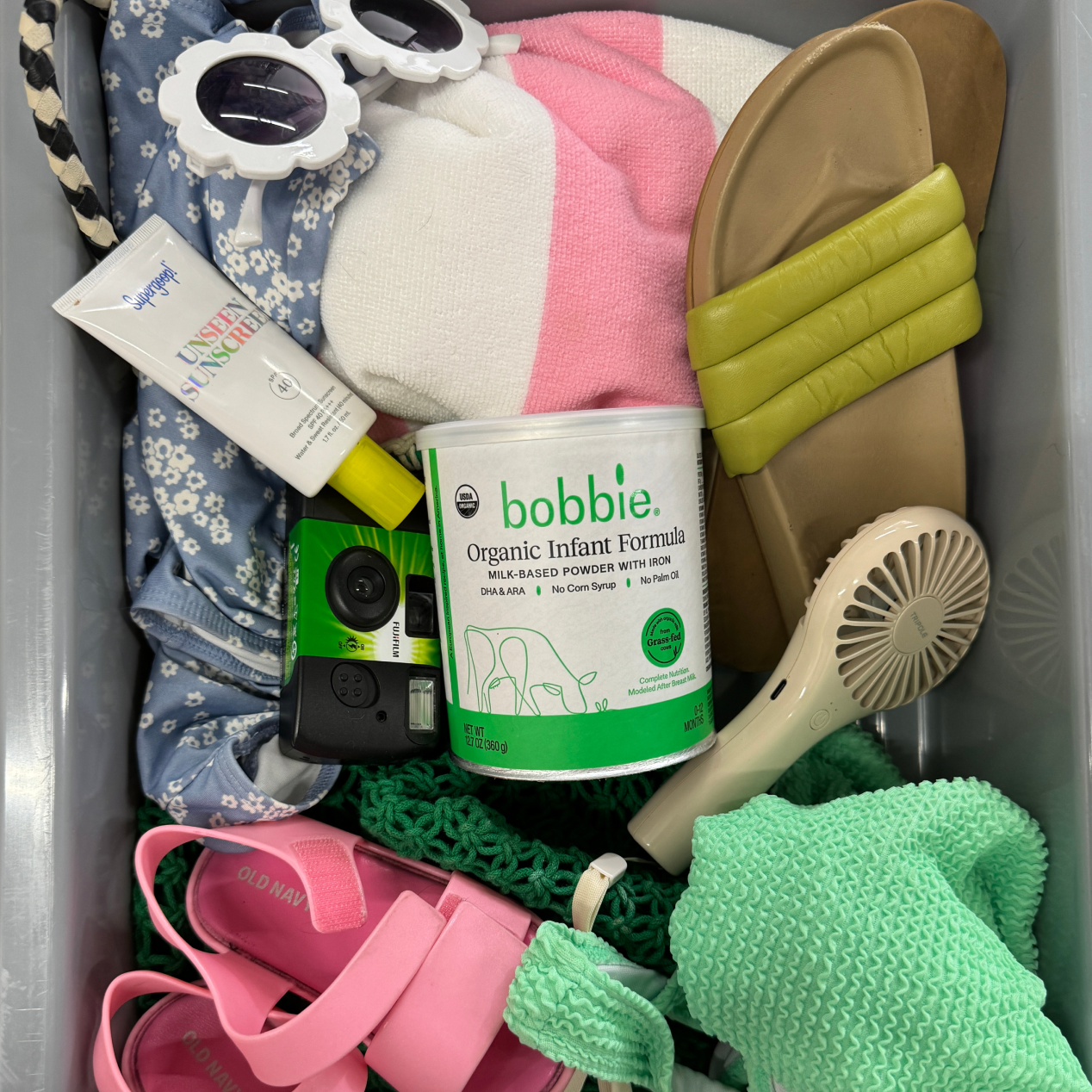 Lifestyle image of a Organic Infant Formula 12.7oz can in a traveling TSA bin.