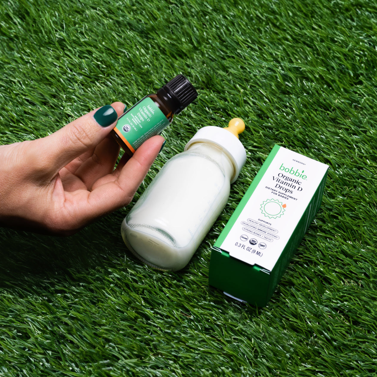 Vitamin D Drops on grass next to a bottle