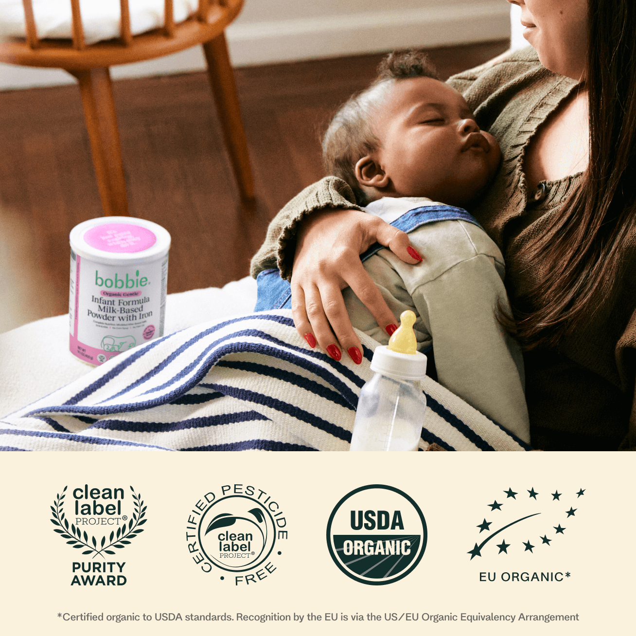 Woman holding a baby with a bobble infant formula container and a bottle on a blanket, with certification logos at the bottom.
