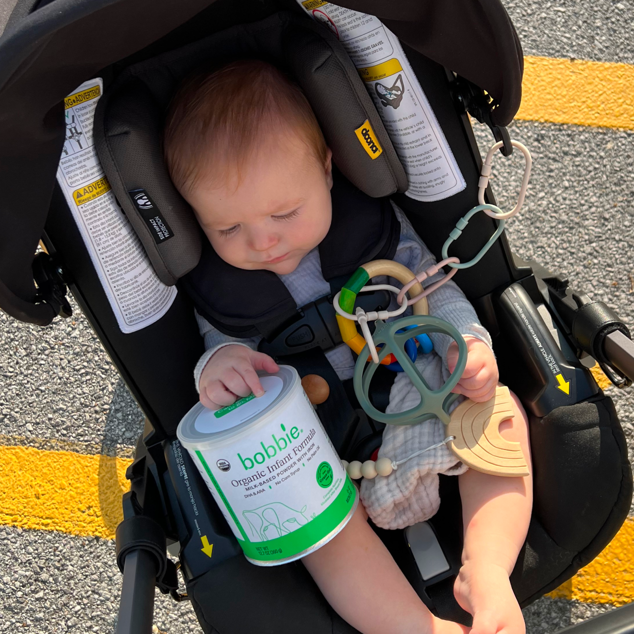 Lifestyle image of a baby holding a can of Organic Infant Formula (12.7oz)